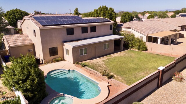 2109 W Wildhorse Dr, Chandler, AZ 85286 - back of house featuring roof mounted solar panels, stucco siding, a fenced backyard, a patio area, and a pool with connected hot tub