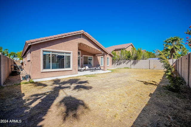 rear view of house with a yard and a patio area