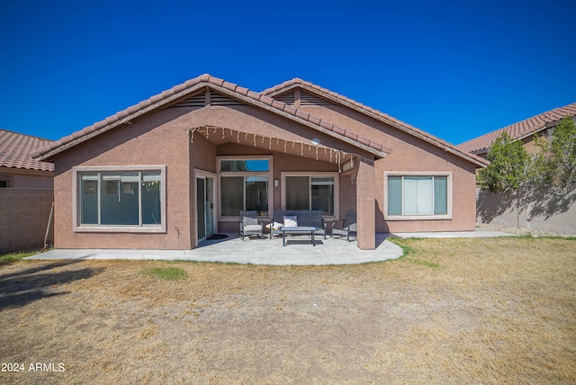 rear view of house with an outdoor hangout area, a lawn, and a patio