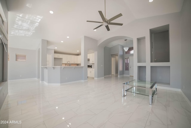 living room with vaulted ceiling, ceiling fan, and sink