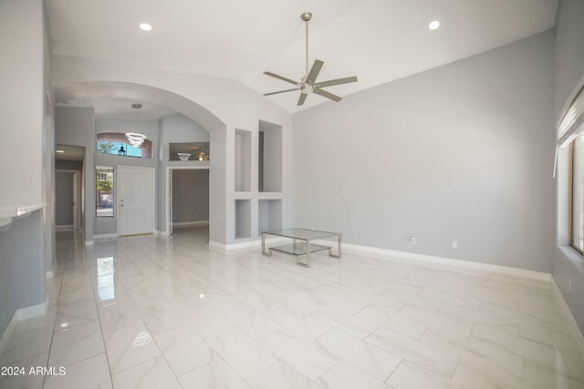 unfurnished living room featuring ceiling fan and high vaulted ceiling