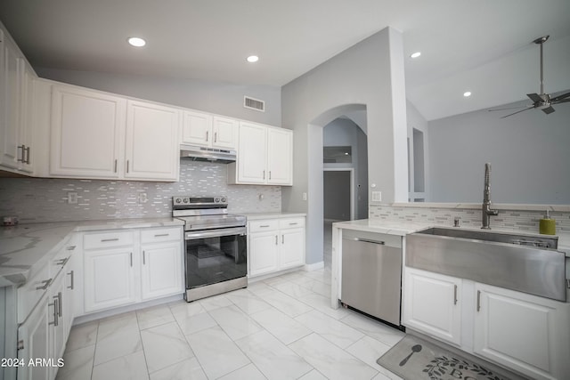 kitchen with lofted ceiling, tasteful backsplash, stainless steel appliances, and white cabinets