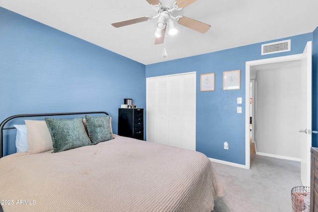 carpeted bedroom with a closet, visible vents, a ceiling fan, and baseboards