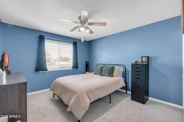 carpeted bedroom featuring baseboards and ceiling fan