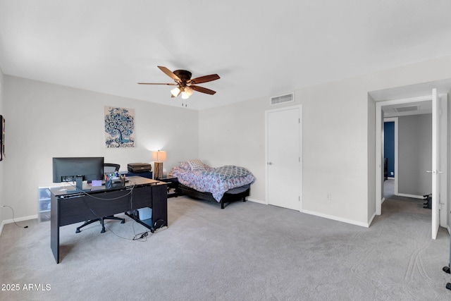 office space featuring light carpet, visible vents, ceiling fan, and baseboards