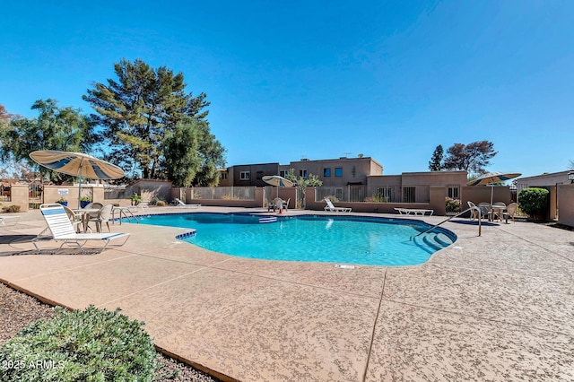 community pool featuring a patio and fence