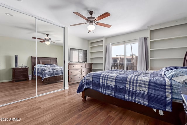 bedroom with ceiling fan, baseboards, and wood finished floors