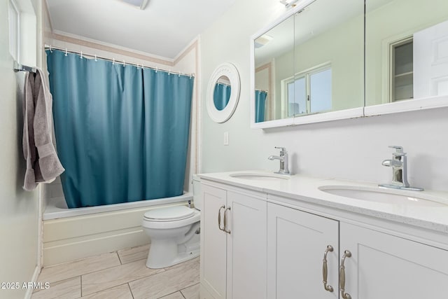 full bath with shower / bath combination with curtain, double vanity, a sink, and toilet