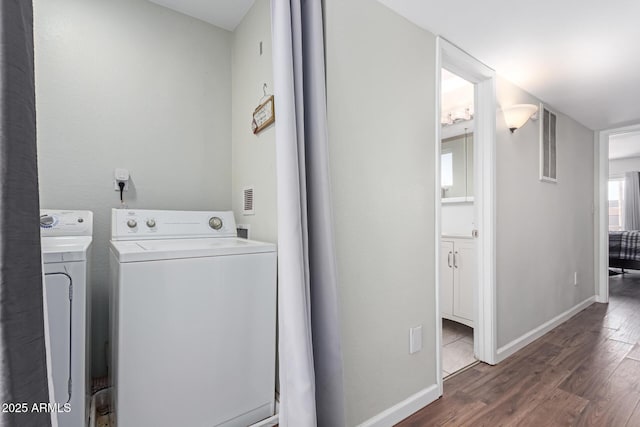 laundry room featuring laundry area, visible vents, baseboards, wood finished floors, and independent washer and dryer