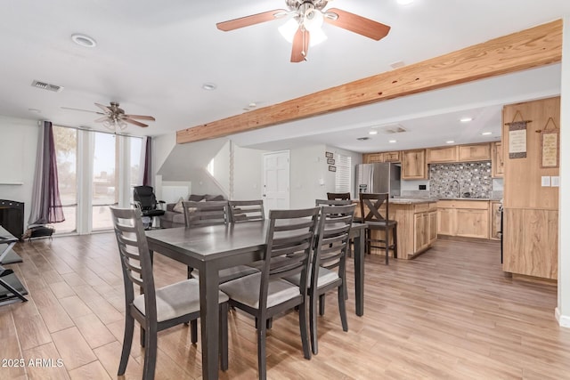 dining room featuring light wood-style flooring, floor to ceiling windows, visible vents, and beamed ceiling