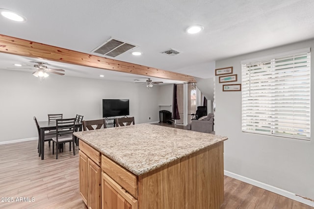 kitchen with baseboards, visible vents, and light wood-style floors