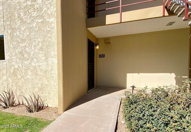 doorway to property featuring visible vents and stucco siding