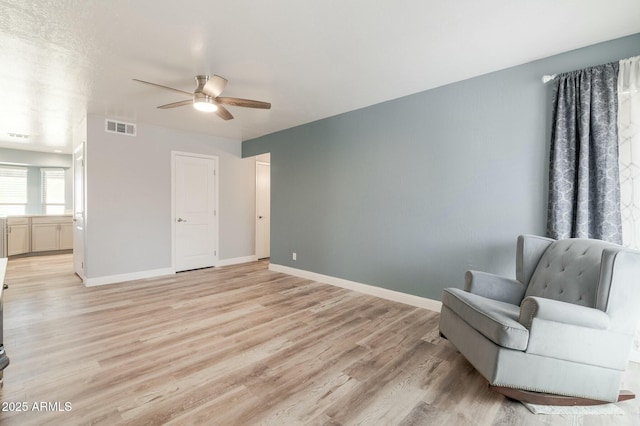 living area featuring light hardwood / wood-style flooring and ceiling fan