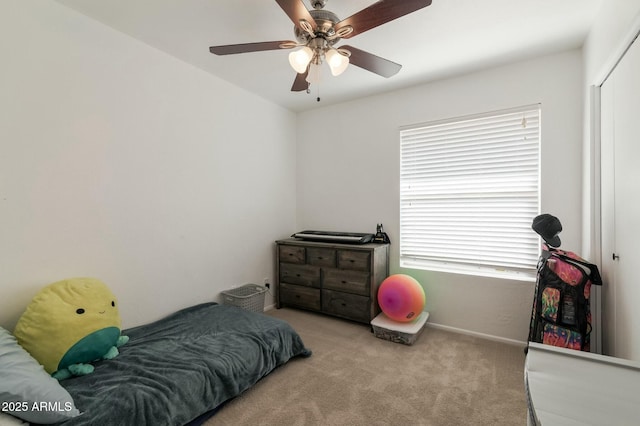 carpeted bedroom featuring multiple windows and ceiling fan