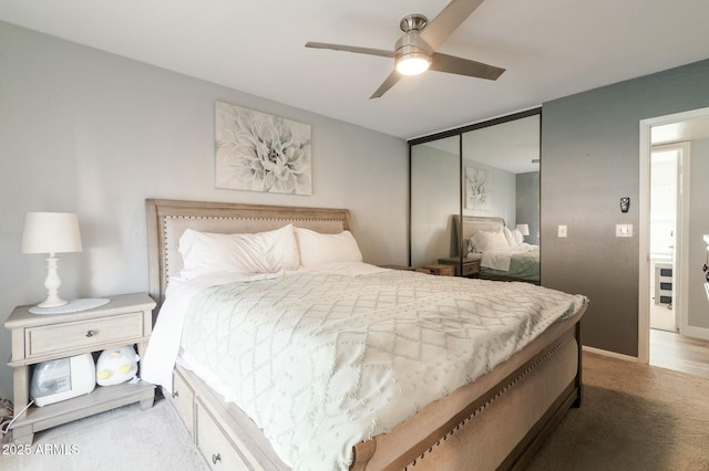 carpeted bedroom featuring ceiling fan and a closet