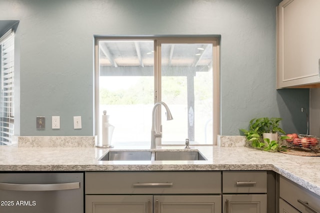 kitchen with dishwasher, sink, and gray cabinetry