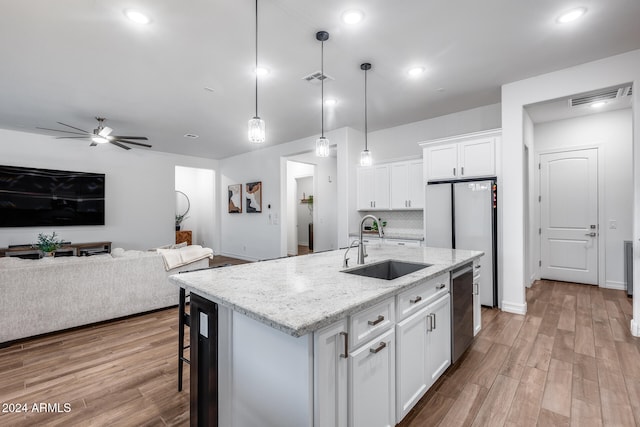 kitchen with a kitchen island with sink, white cabinets, decorative light fixtures, and ceiling fan