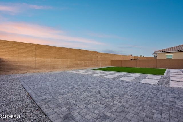 yard at dusk with a patio area