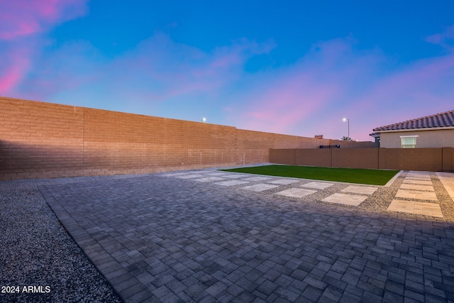 yard at dusk featuring a patio