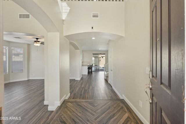 entryway featuring ceiling fan, dark hardwood / wood-style flooring, a high ceiling, and a wealth of natural light