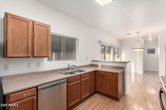 2652 E Riviera Dr, Chandler, AZ 85249 - kitchen with stainless steel dishwasher, a sink, a peninsula, light wood-style flooring, and brown cabinetry