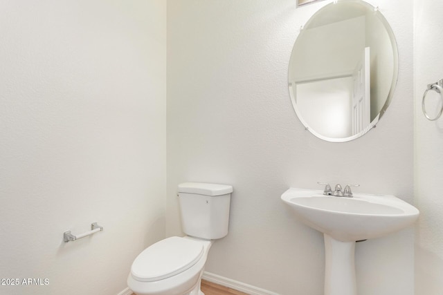 2652 E Riviera Dr, Chandler, AZ 85249 - half bathroom with toilet, baseboards, and wood finished floors