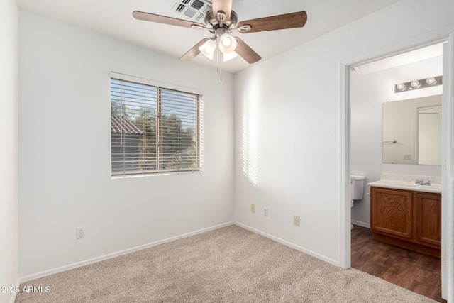 2652 E Riviera Dr, Chandler, AZ 85249 - unfurnished bedroom featuring ensuite bath, dark carpet, baseboards, and ceiling fan