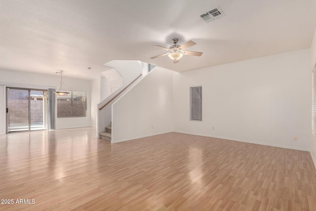 2652 E Riviera Dr, Chandler, AZ 85249 - unfurnished living room with light wood-type flooring, ceiling fan, stairway, and baseboards