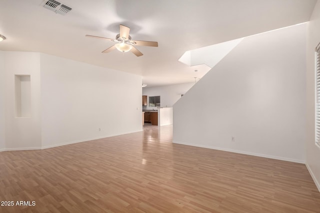 2652 E Riviera Dr, Chandler, AZ 85249 - unfurnished living room featuring a ceiling fan, light wood-style flooring, and baseboards
