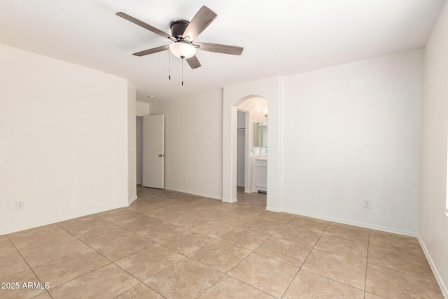5439 W Sands Rd, Glendale, AZ 85301 - unfurnished room featuring arched walkways, a ceiling fan, light tile patterned floors, and baseboards