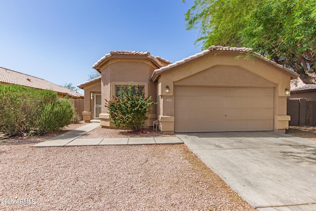 5439 W Sands Rd, Glendale, AZ 85301 - mediterranean / spanish house with stucco siding, an attached garage, driveway, a tile roof, and fence