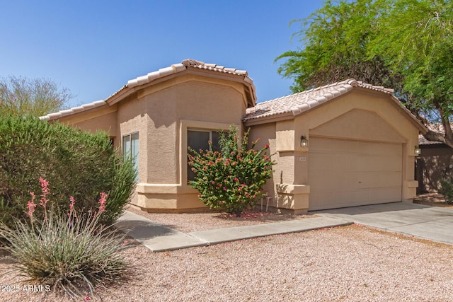 5439 W Sands Rd, Glendale, AZ 85301 - view of front of house featuring stucco siding, concrete driveway, a tiled roof, and an attached garage