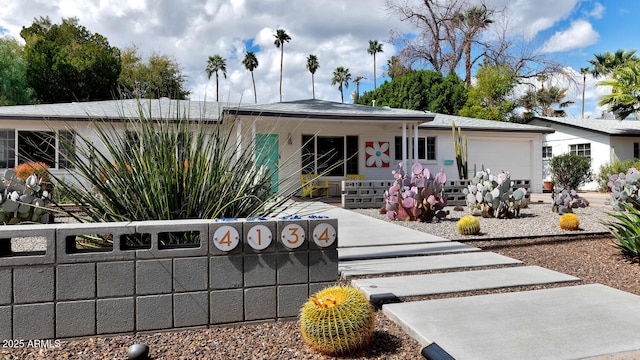 view of front facade with an attached garage and fence