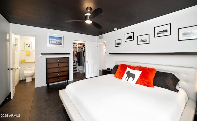 bedroom featuring visible vents, ensuite bath, dark tile patterned flooring, a closet, and a walk in closet