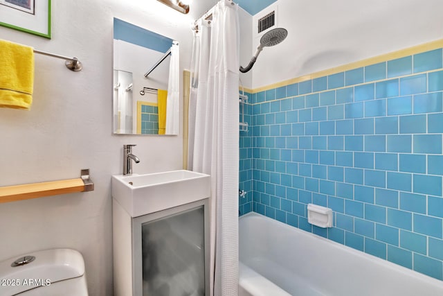 bathroom featuring visible vents, vanity, toilet, and shower / tub combo