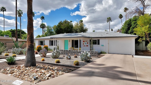 single story home featuring a garage, a porch, and concrete driveway