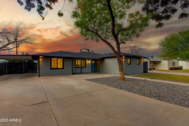 view of front of property featuring concrete driveway and fence