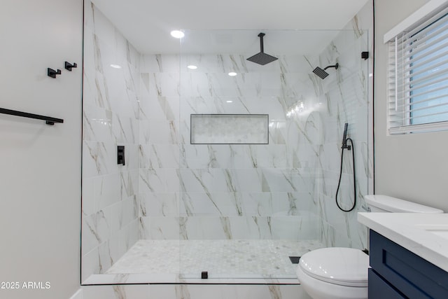 full bathroom with a marble finish shower, toilet, and vanity