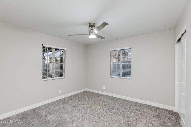 unfurnished bedroom with a closet, baseboards, carpet, and a ceiling fan