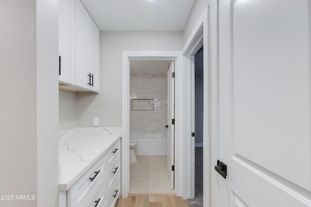 bathroom with vanity, a bath, wood finished floors, walk in shower, and toilet