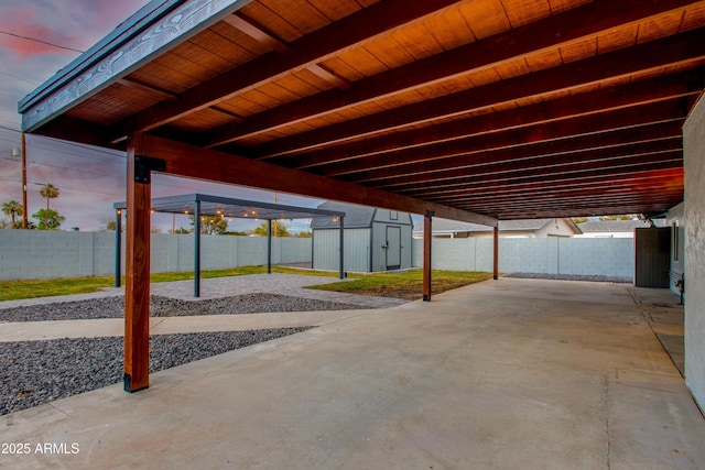 view of patio featuring a storage shed, a fenced backyard, and an outdoor structure