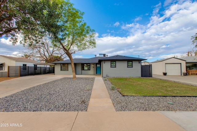 view of front of property with a gate, a detached garage, a front yard, and fence