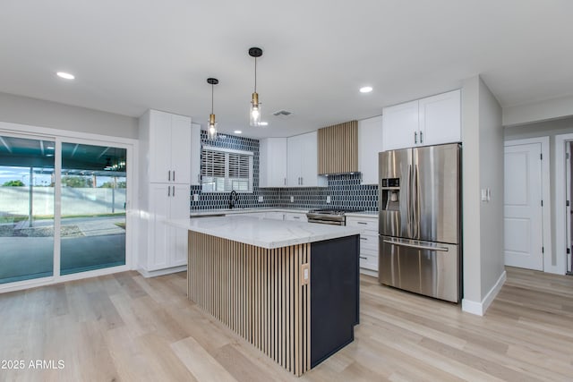 kitchen with backsplash, range hood, stainless steel appliances, white cabinets, and light stone countertops