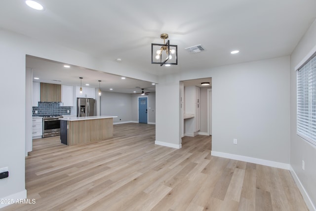 kitchen featuring visible vents, open floor plan, light countertops, appliances with stainless steel finishes, and light wood-style floors