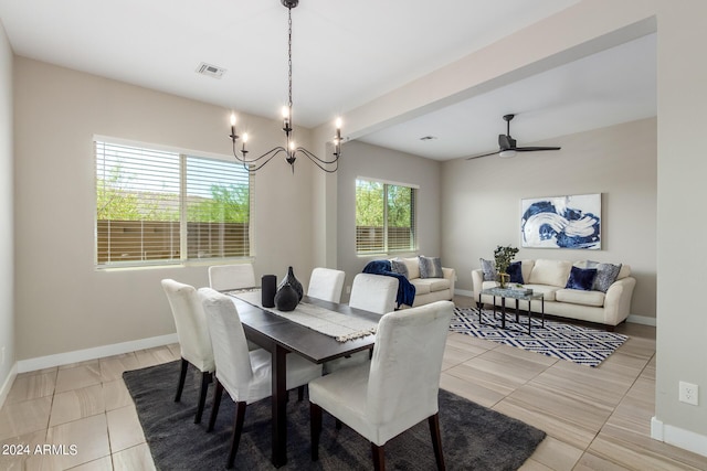 tiled dining space with ceiling fan with notable chandelier