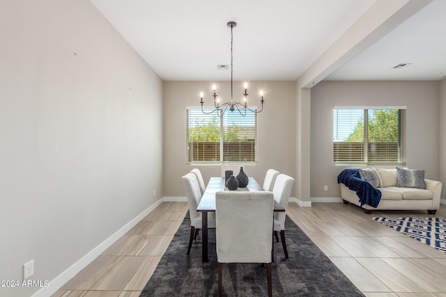 dining space with a notable chandelier and light tile patterned flooring