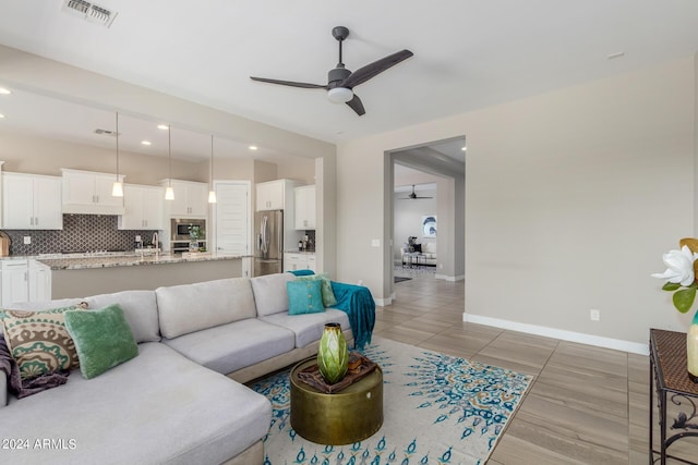 living room with ceiling fan and sink