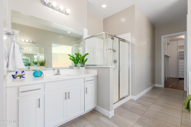 bathroom featuring vanity and a shower with door