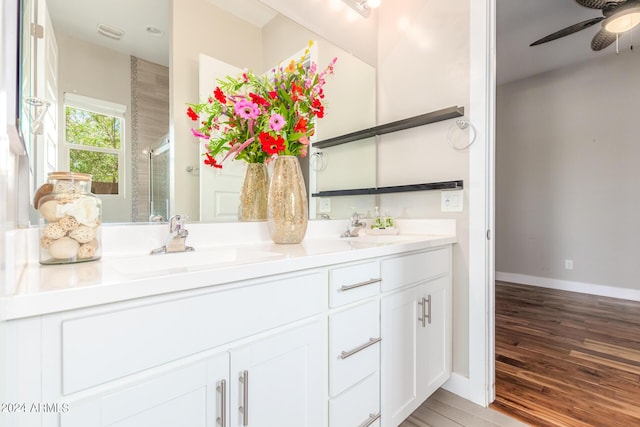 bathroom with vanity, ceiling fan, wood-type flooring, and walk in shower