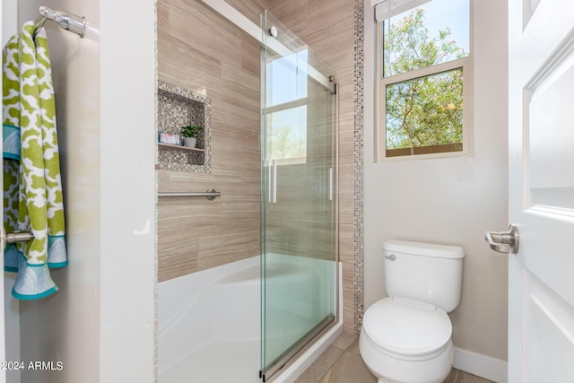 bathroom featuring toilet and an enclosed shower